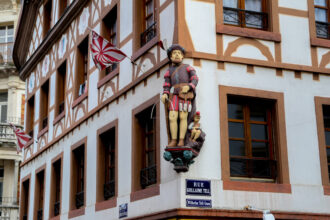 Statua di Guglielmo Tell sulla facciata di un edificio storico nel centro di Mulhouse © Devid Rotasperti Photographer