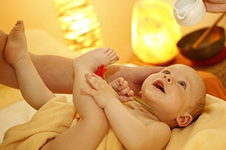 Vacanze con neonati, benessere autunnale ai Kinderhotel, massaggio neonatale