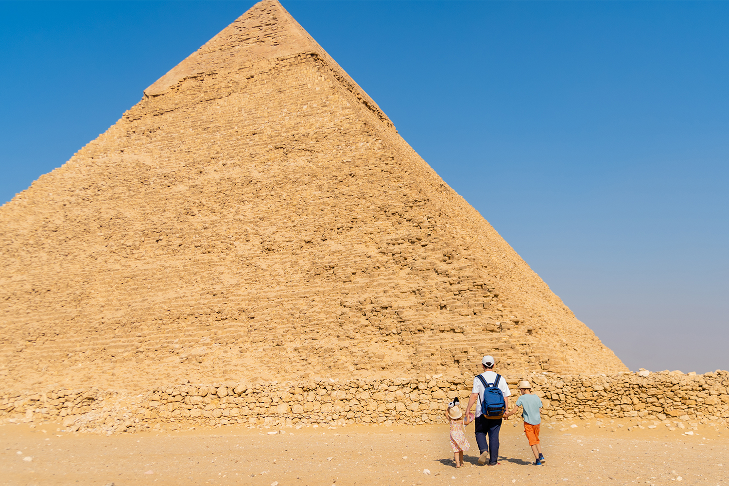 Padre e figli camminano davanti alla piramide di Chefren sull'altopiano di Giza @ Igor Bostanika